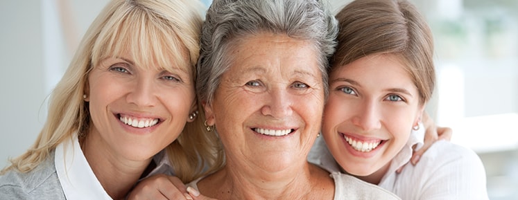 daughter, mother, and grandmother show off their white teeth
