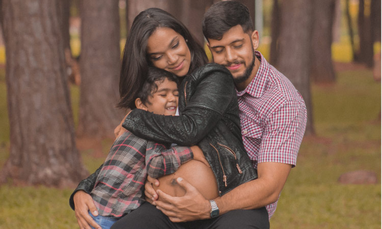 pregnant woman hugging son and husband after routine dental care 