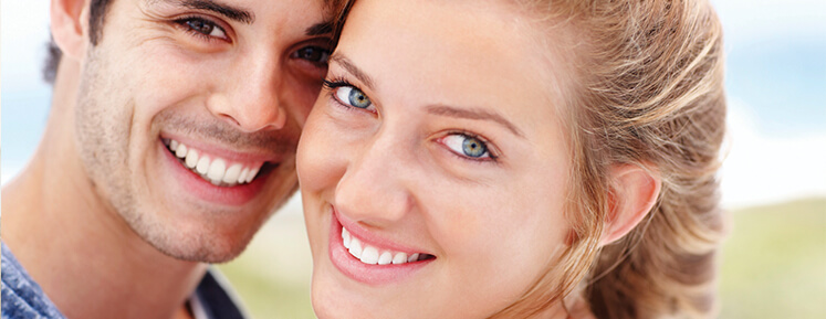 couple smiling and showing off their whitened teeth