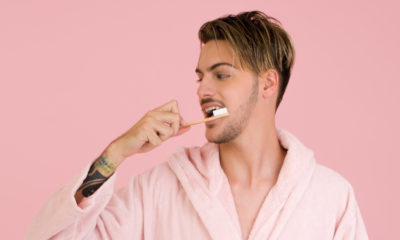 man in a bathrobe brushing his teeth