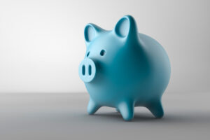 Blue piggy bank on a gray background to symbolize saving money with our in-house dental plan