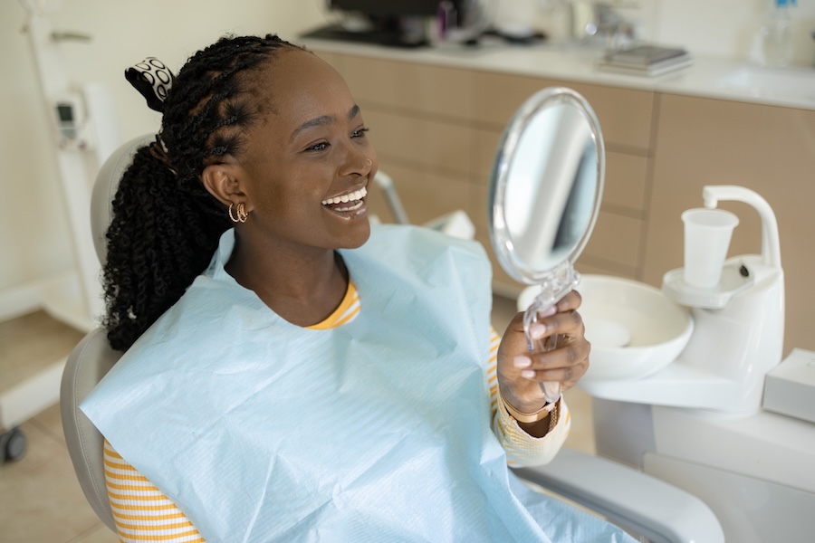 woman smiling in dental chair after Dr. Gupta's dental services